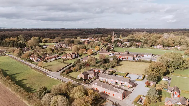 A bird's eye view of rural Cheshire with fields, trees and a few houses