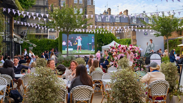 People watching tennis on a big screen 