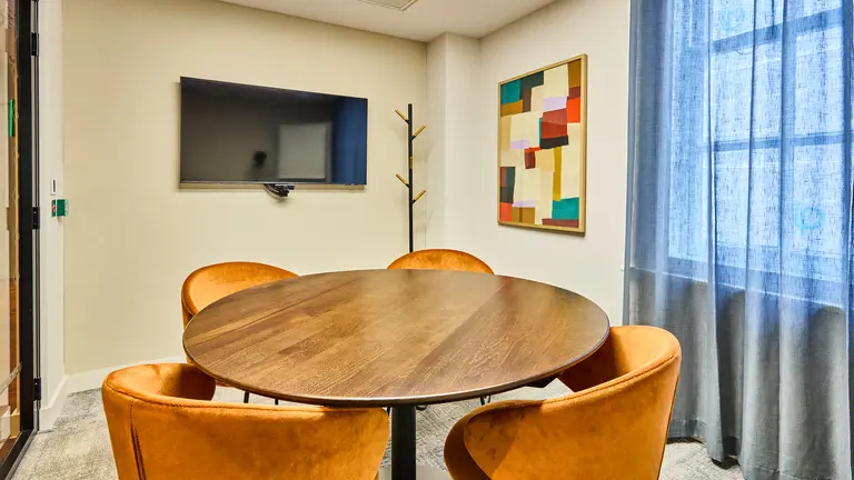 A meeting room with a circular table and four chairs