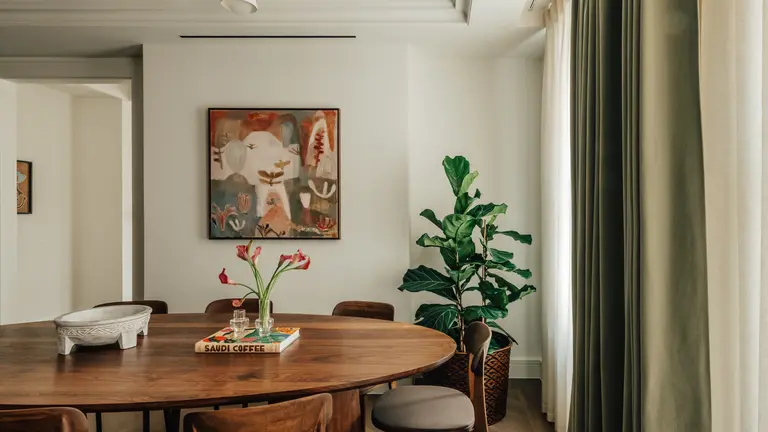 A dining room table with a picture in the background 