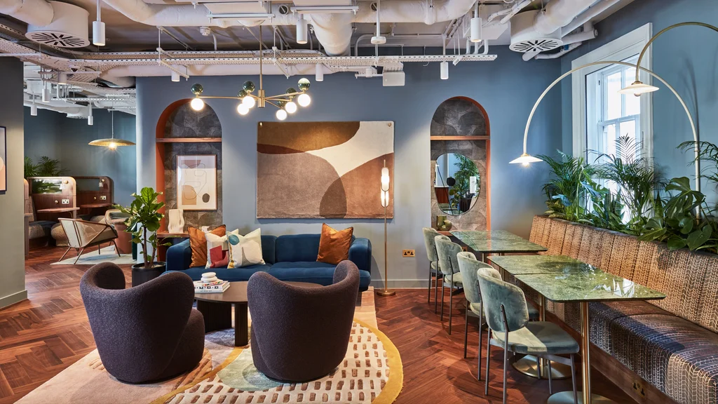 Inside of an office with blue sofas and chairs, artwork on the walls