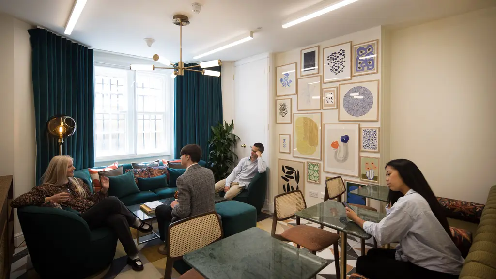 People working in a room with chairs and sofas