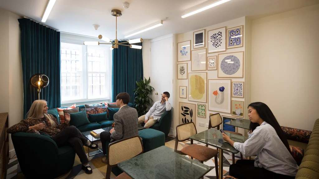 People working in a room with chairs and sofas
