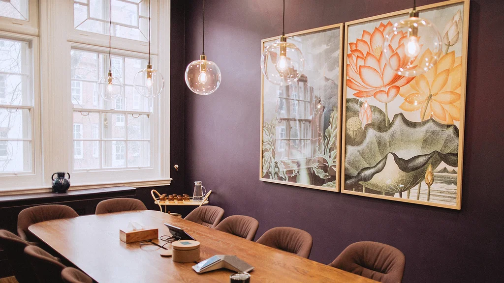 A meeting room with purple walls and artwork