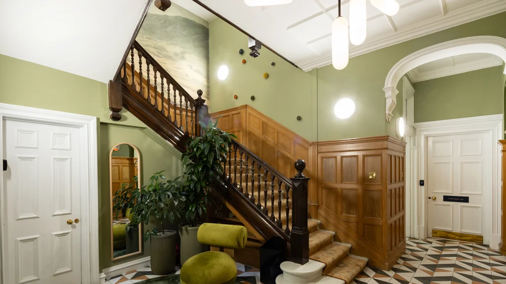 Staircase with a green chair at the foot of the stairs