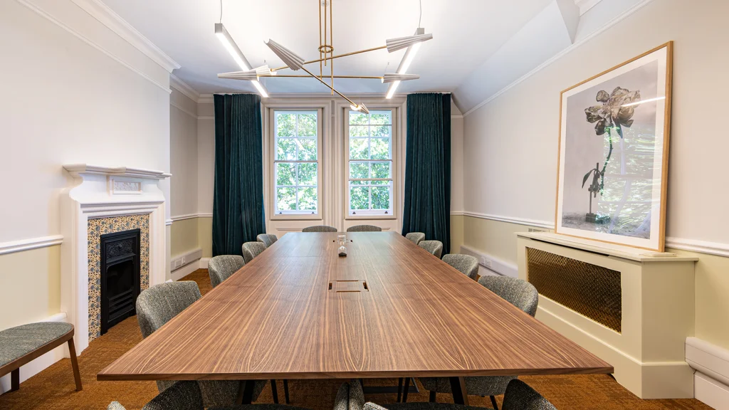 A meeting room with a fireplace and large painting