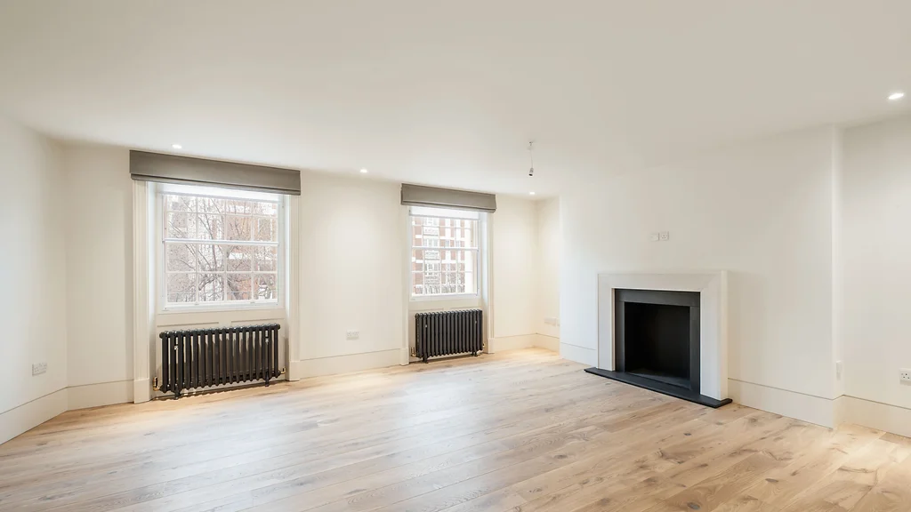 Empty room with a fireplace and two windows