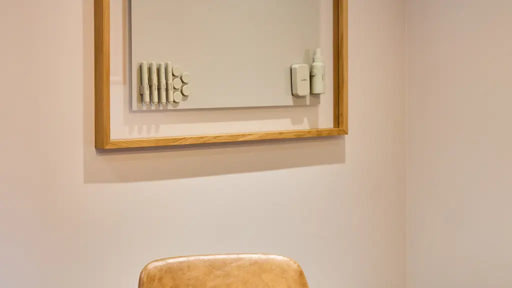A chair and table with a whiteboard on the wall 