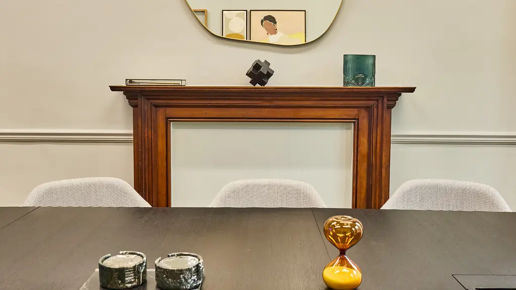 A table and chairs with a fireplace in the background
