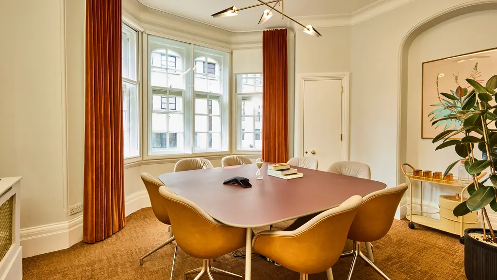 A meeting room with a table and chairs