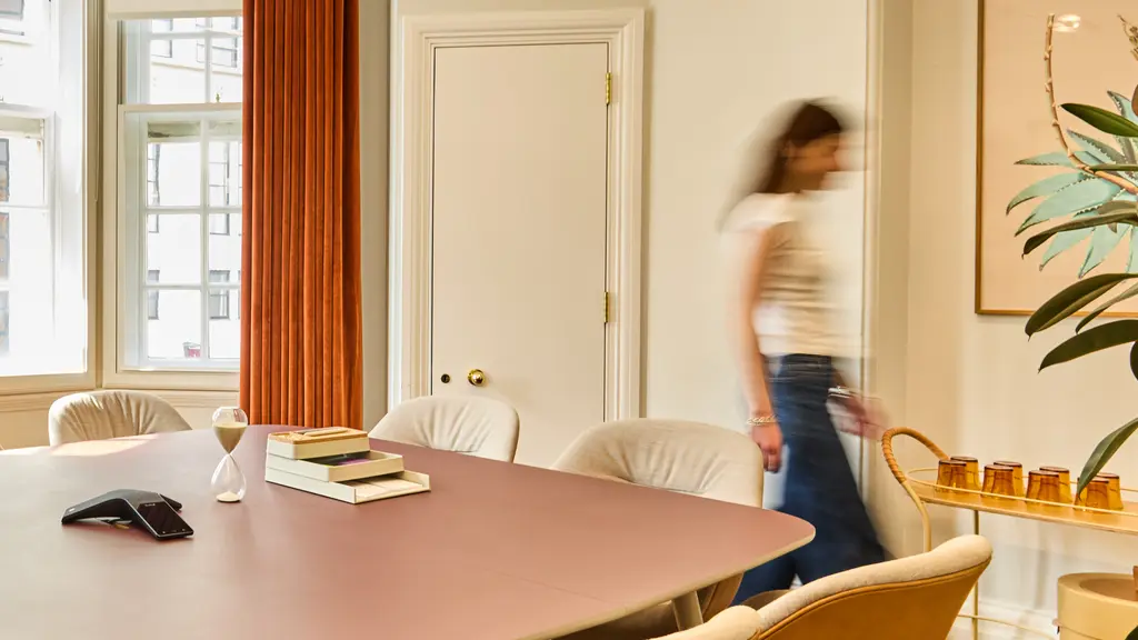 A meeting room with a woman walking through