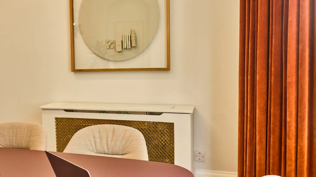 A table and chairs with a circular whiteboard on the wall 