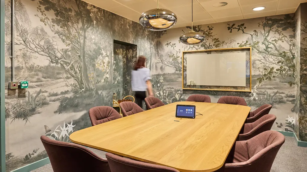 A meeting room with a table and chairs