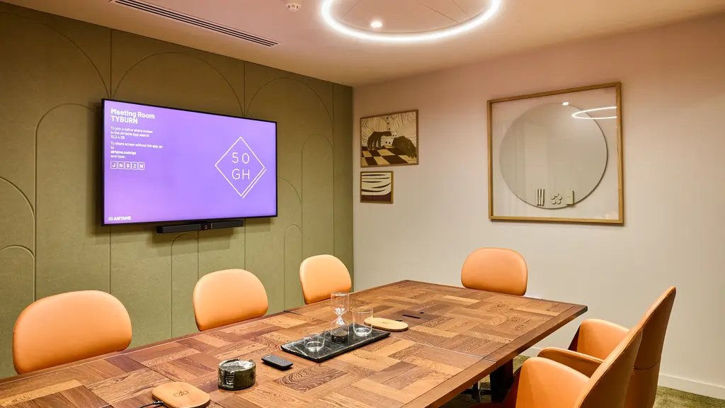 A meeting room with a screen and a whiteboard