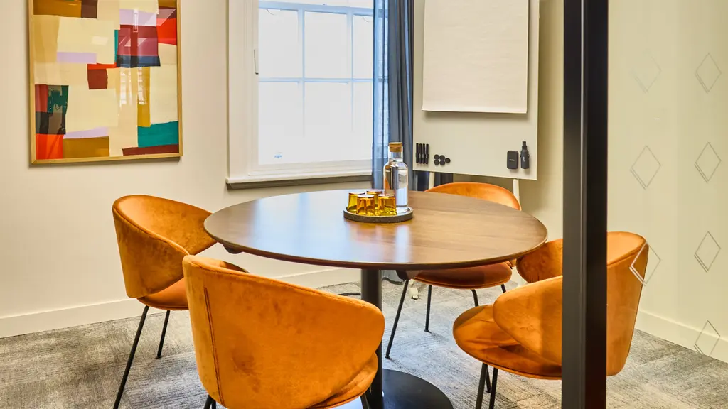 A meeting room with a circular table and four chairs