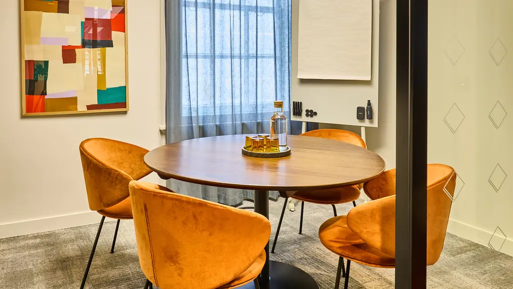 A meeting room with a circular table and four chairs