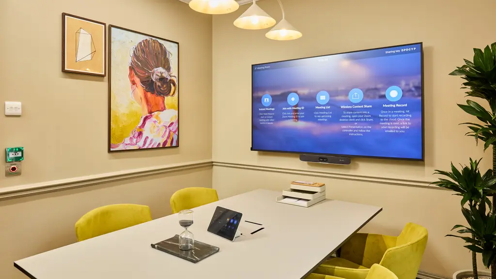 Meeting room with yellow chairs and a TV screen