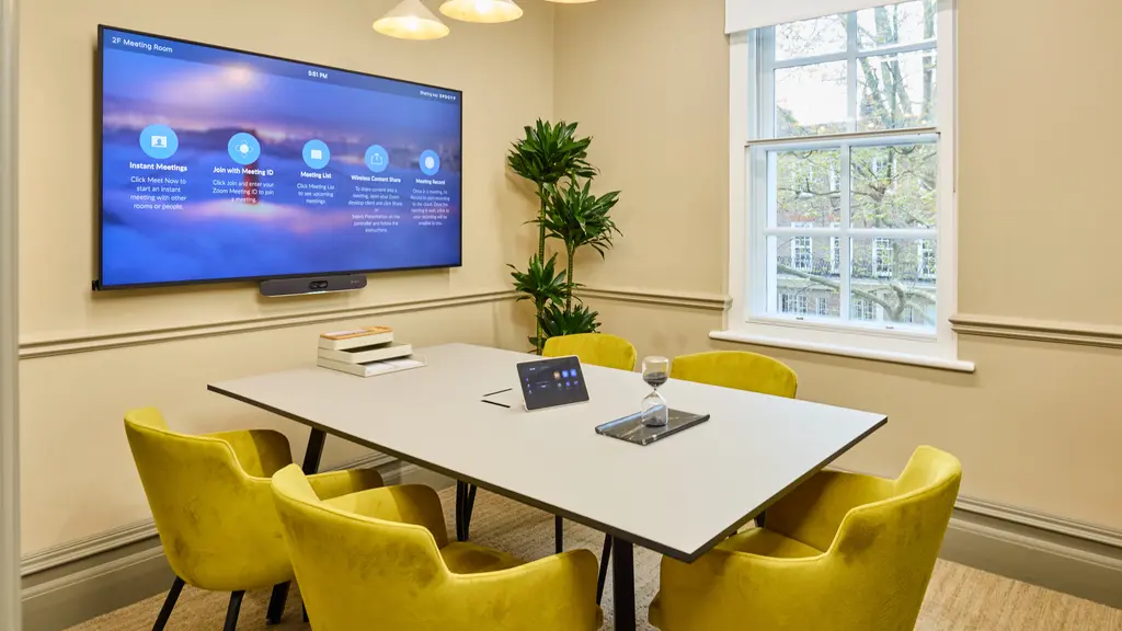 Meeting room with yellow chairs and a TV screen