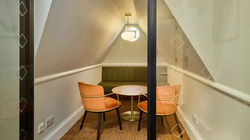 A small meeting room with two chairs and a round table