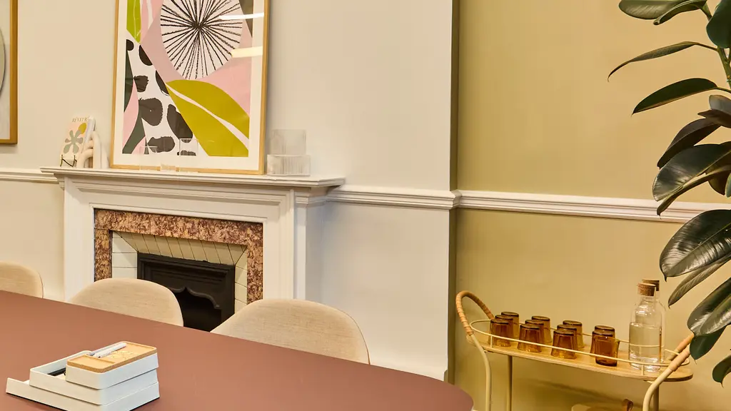 A meeting room with a table, chairs and artwork on the walls