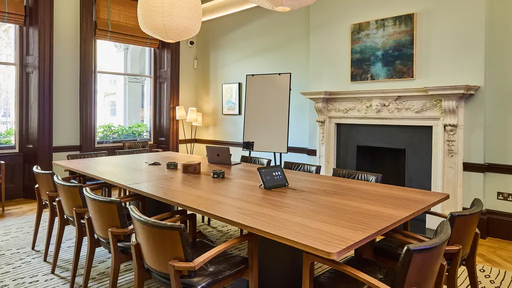 A meeting room with a long table and chairs