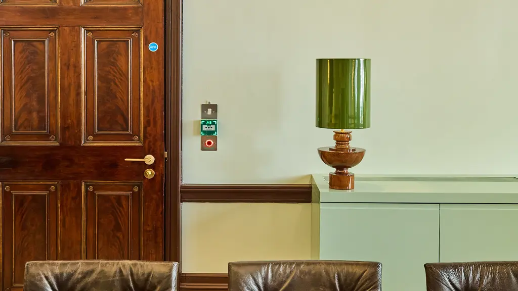 A table, chairs and green lamp