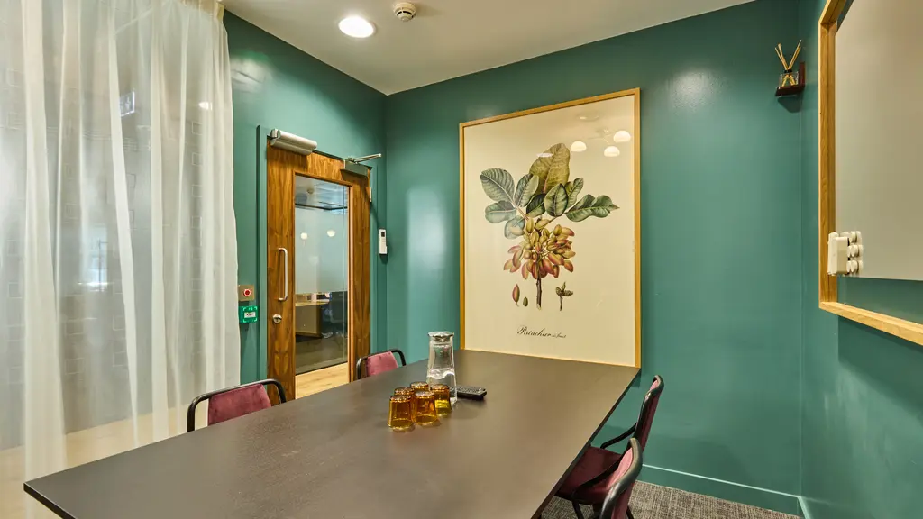 A meeting room with a table, chairs and artwork on the walls