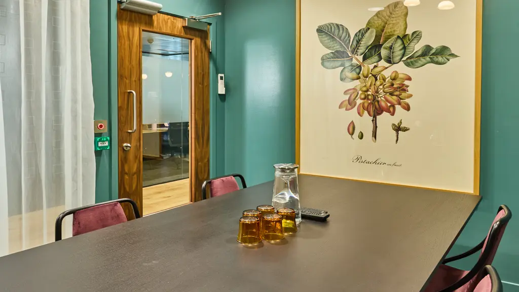 A meeting room with a table, chairs and artwork