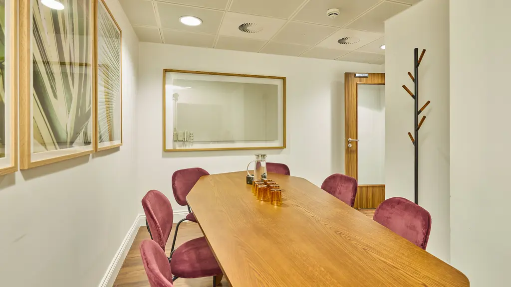 A meeting room with a table, chairs and artwork on the walls