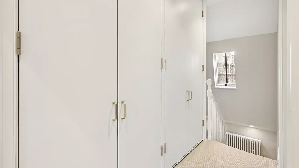 Top of stairs with storage cupboards