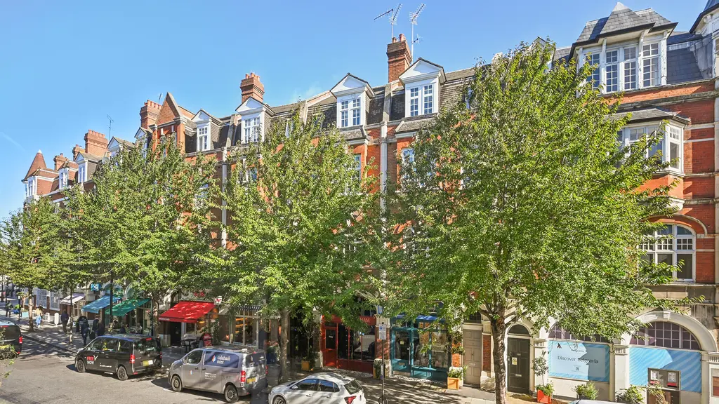 Street view showing row of houses with trees in front