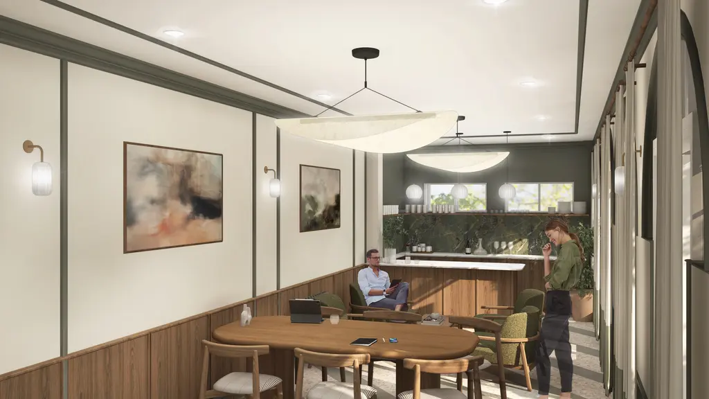 One person sitting and another standing in a room with a table and chairs