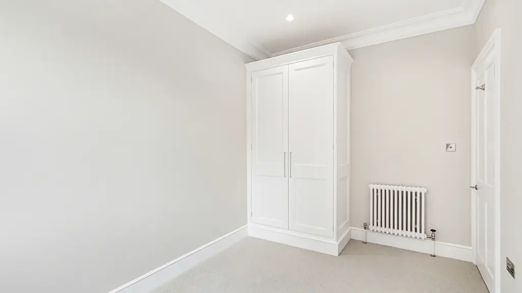 Bedroom with white walls and a wardrobe 