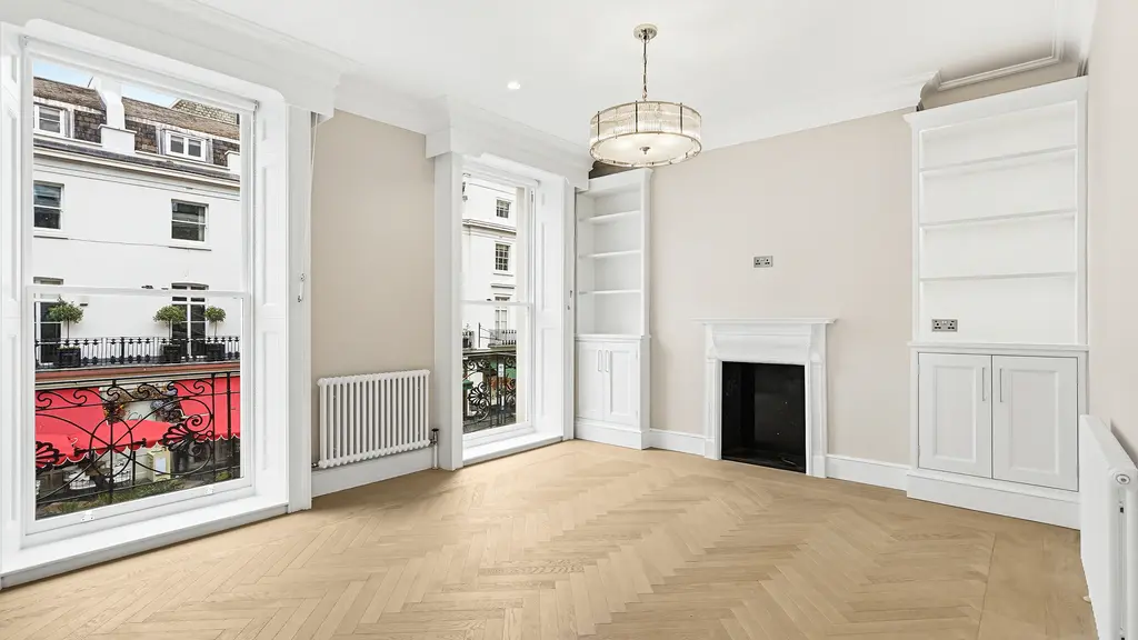 Empty room with two windows and a fireplace
