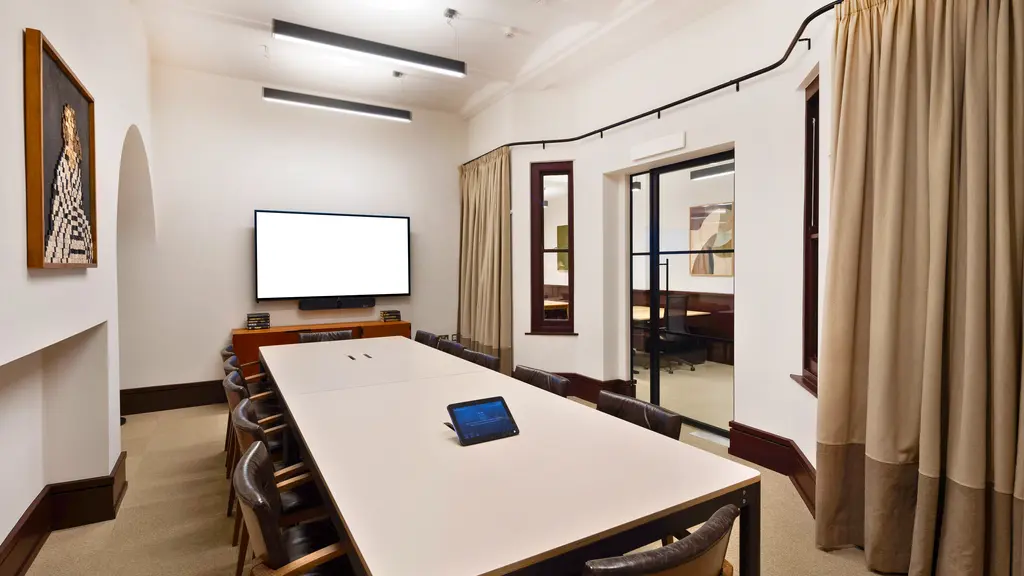 A meeting room with a large table and chairs 