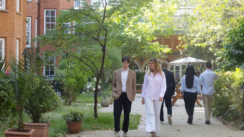 A man and a woman walking through a leafy garden