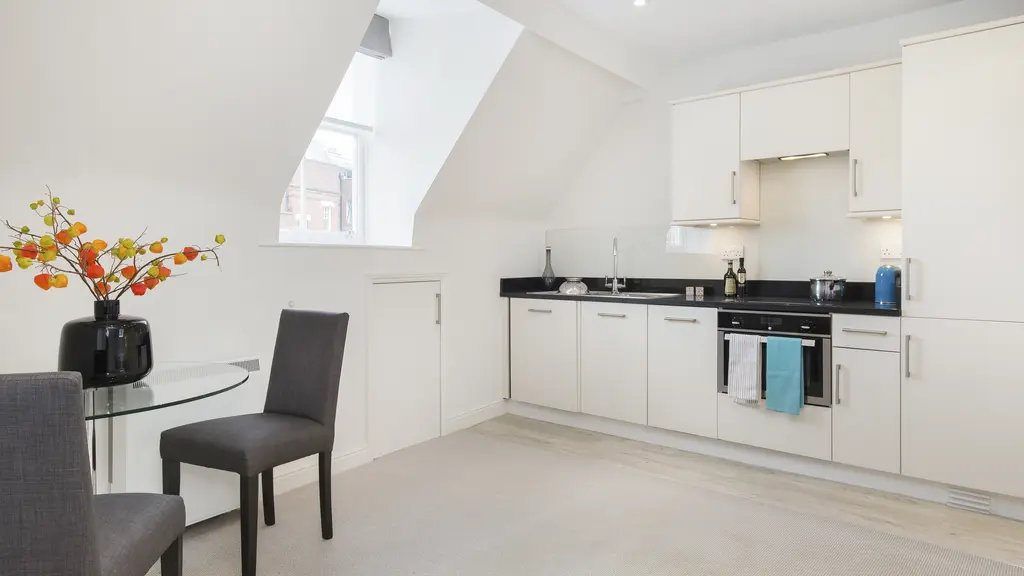 Studio apartment with a kitchen, dining table and chairs 