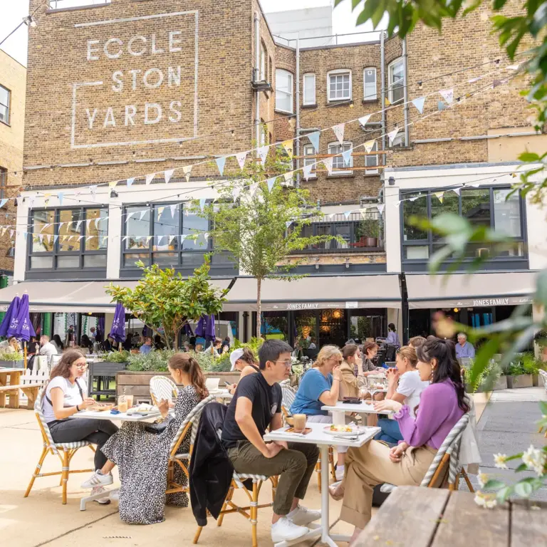 People dining outside in Eccleston Yards