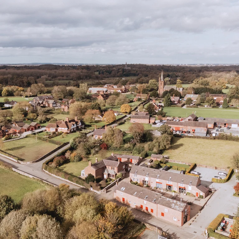 A bird's eye view of rural Cheshire with fields, trees and a few houses