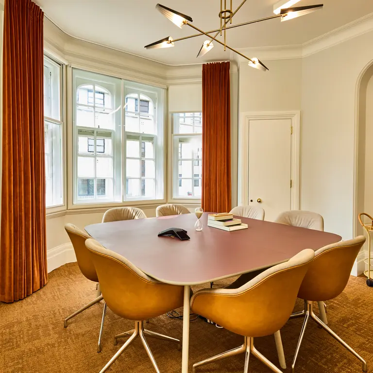 A meeting room with a table and chairs