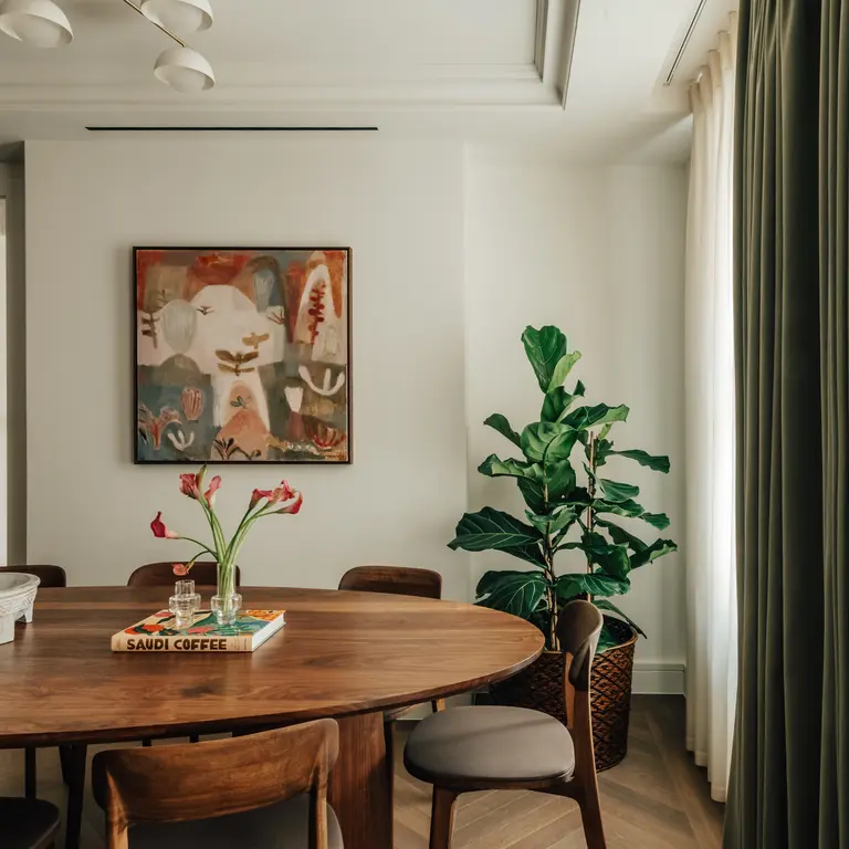 A dining room table with a picture in the background 